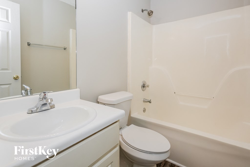 a white bathroom with a sink toilet and shower
