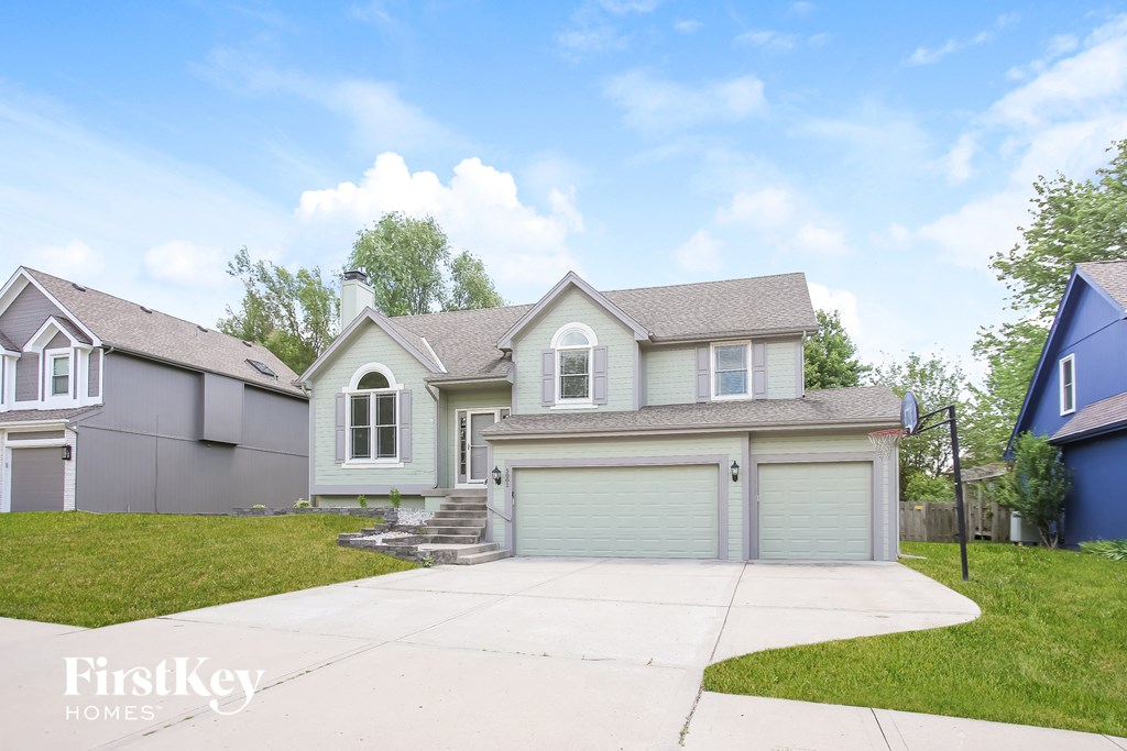 a blue and white house with a garage and a driveway