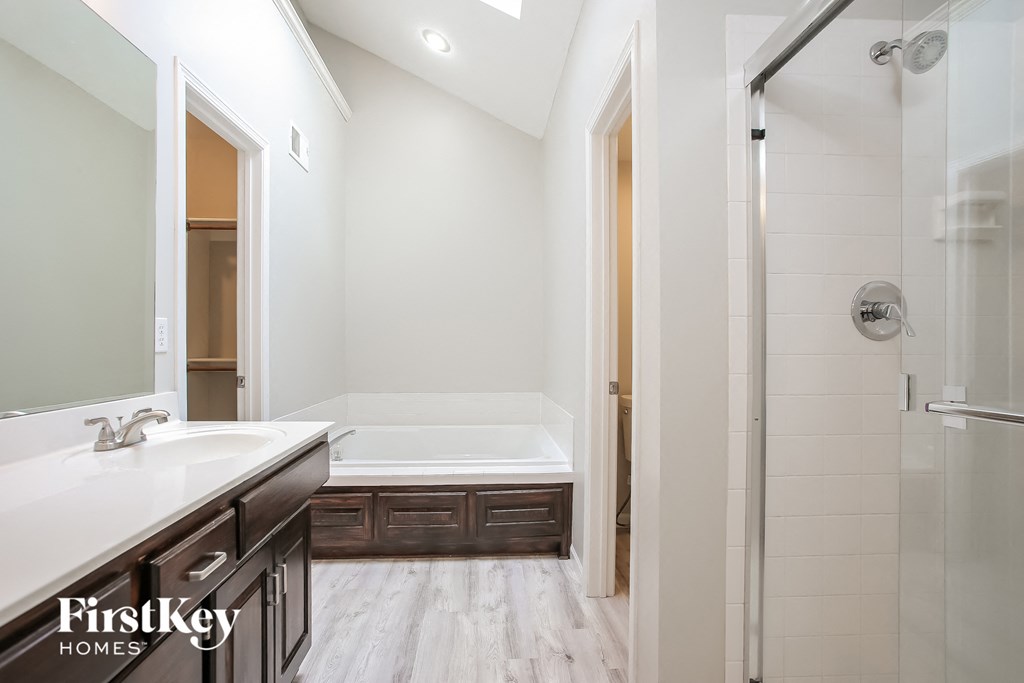 a bathroom with a tub and a sink and a shower