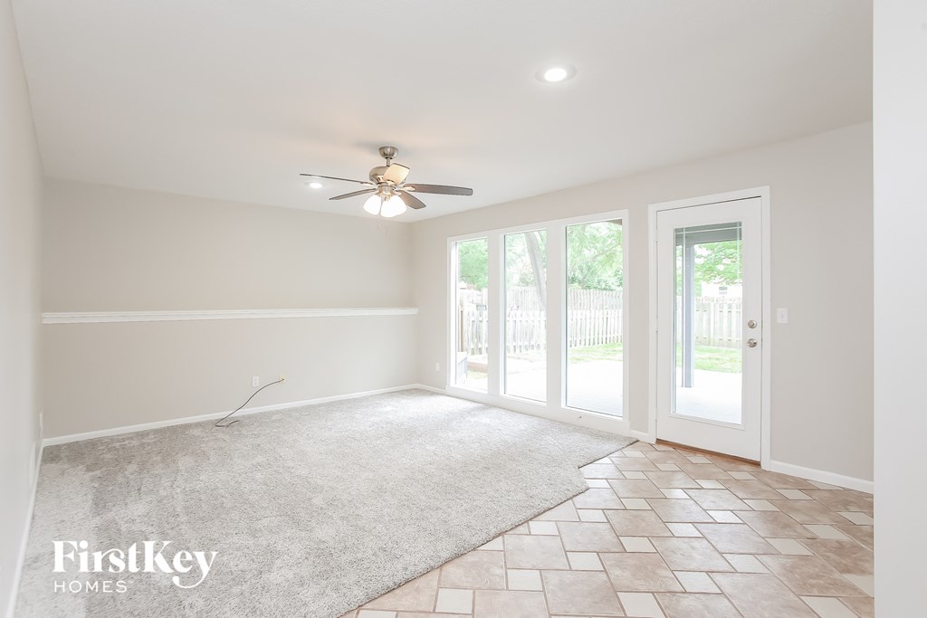a living room with a ceiling fan and a rug