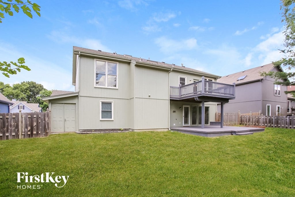 a white house with a yard and a deck on the side