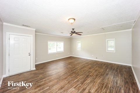 the living room of an empty house with wood floors and a ceiling fan