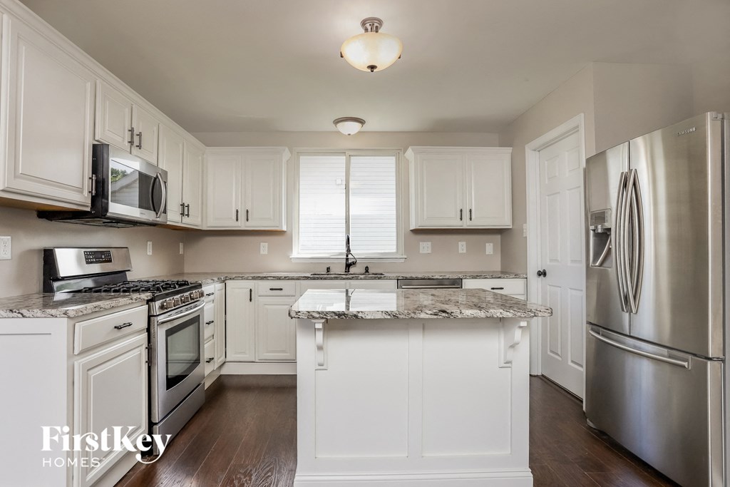 a kitchen with white cabinets and stainless steel appliances