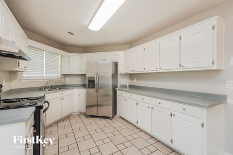a kitchen with white cabinets and a stainless steel refrigerator