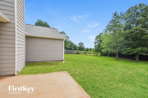 a backyard with a garage and a grassy area and a lawn