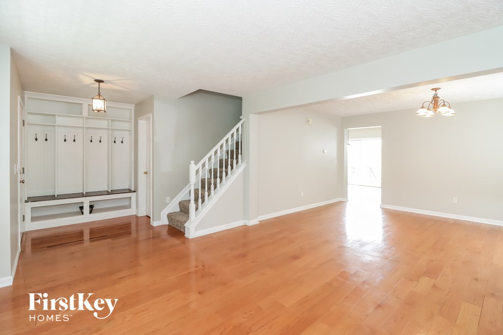 a renovated living room with a staircase and wood floors