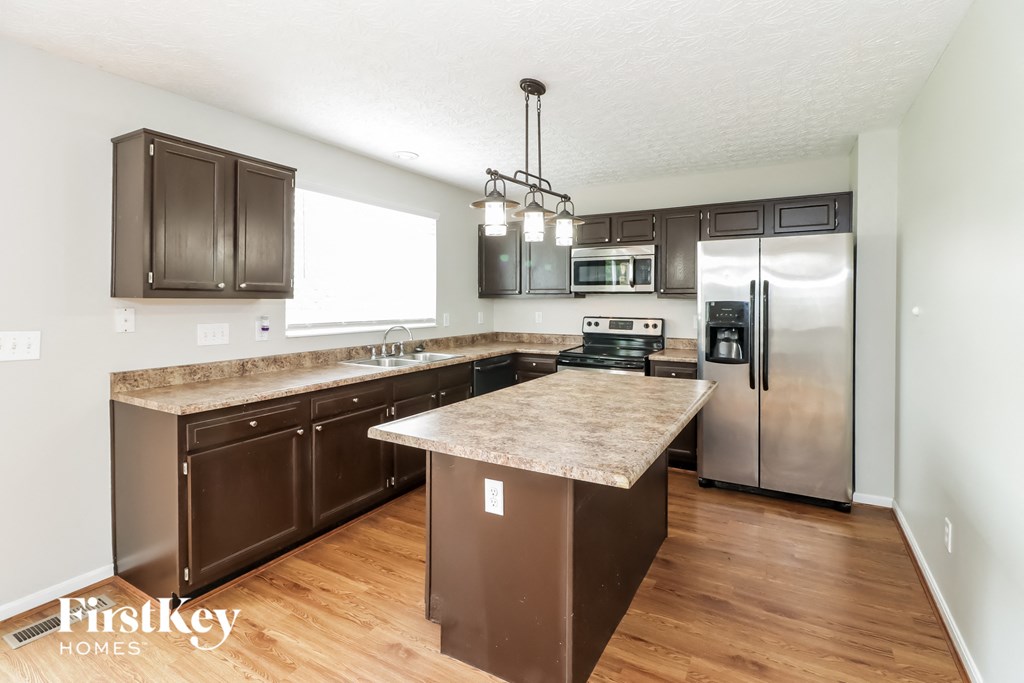 a kitchen with stainless steel appliances and a marble counter top