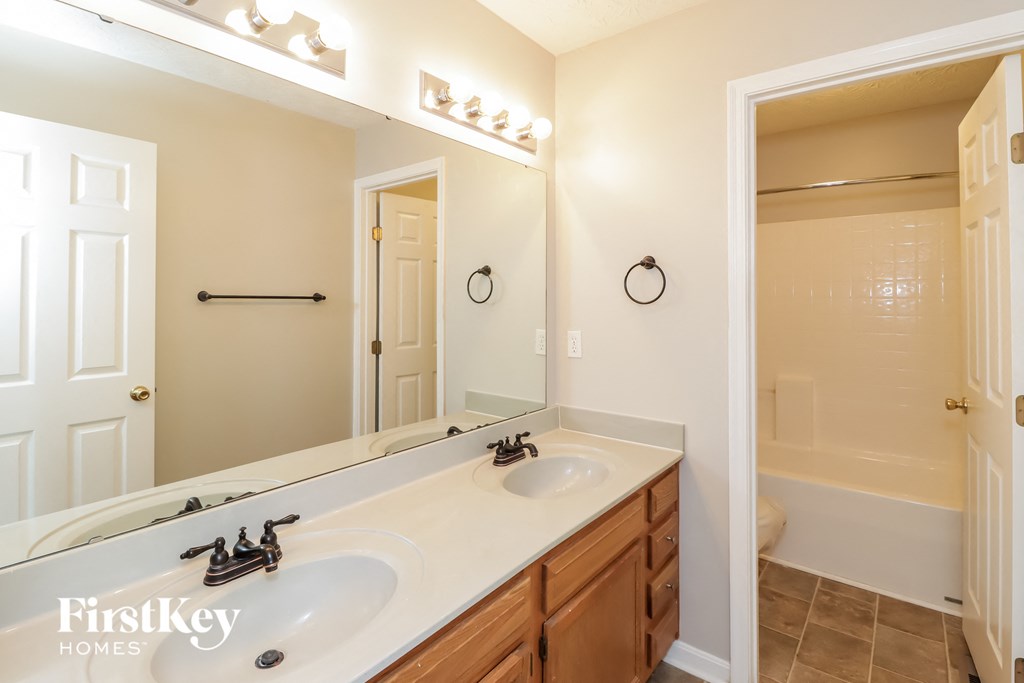 a bathroom with a white sink and a large mirror