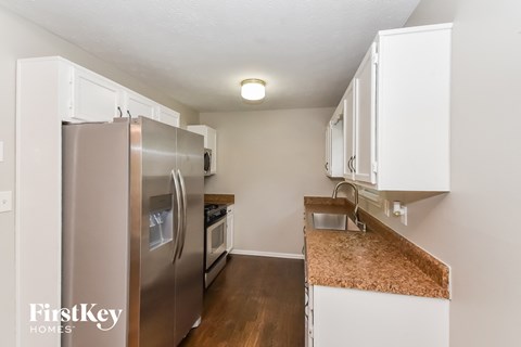 a kitchen with white cabinets and a stainless steel refrigerator