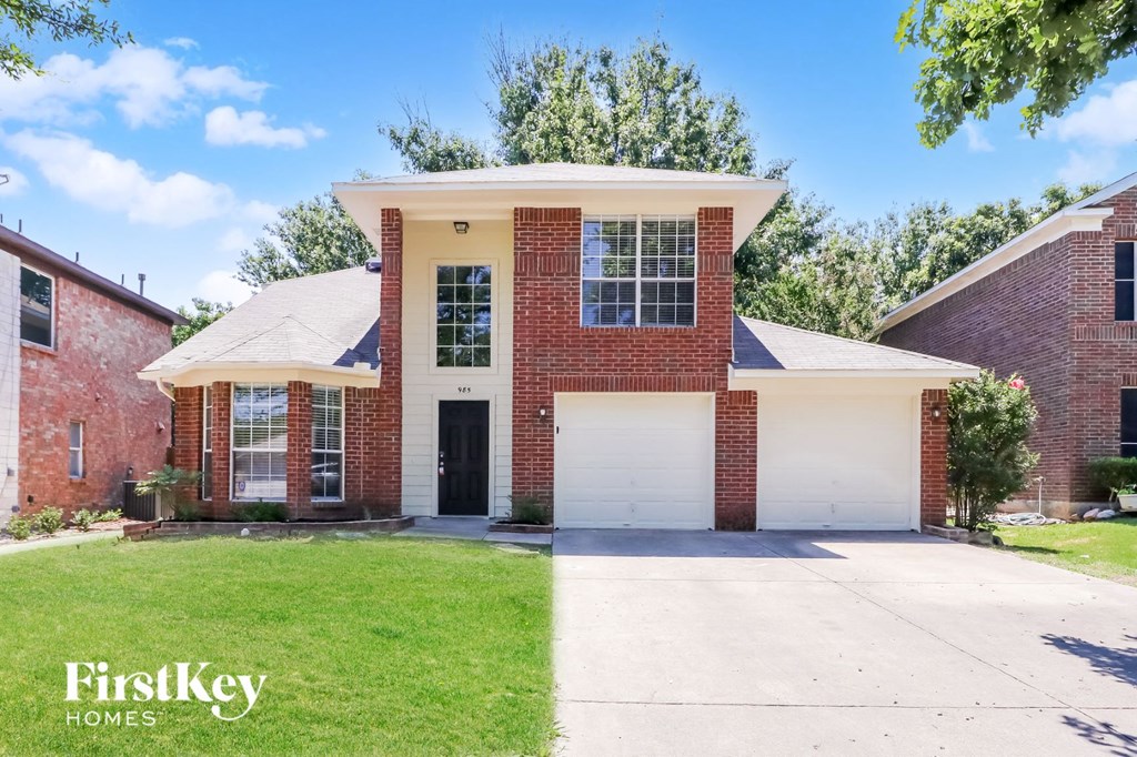 A brick house with a garage door is for sale.