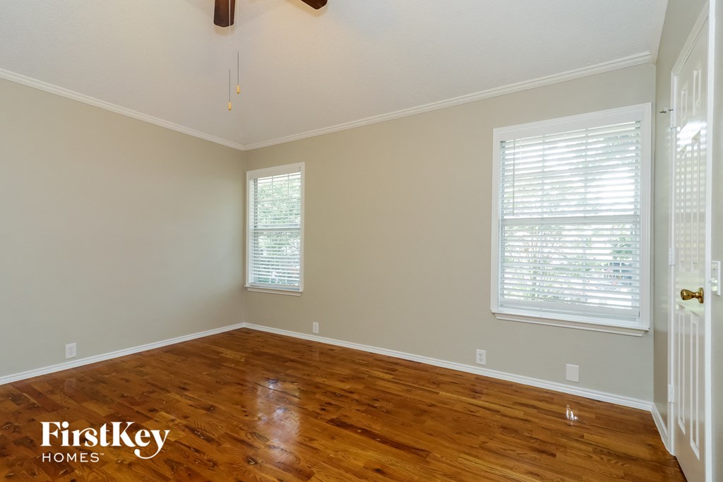 A room with wooden floors and a ceiling fan.