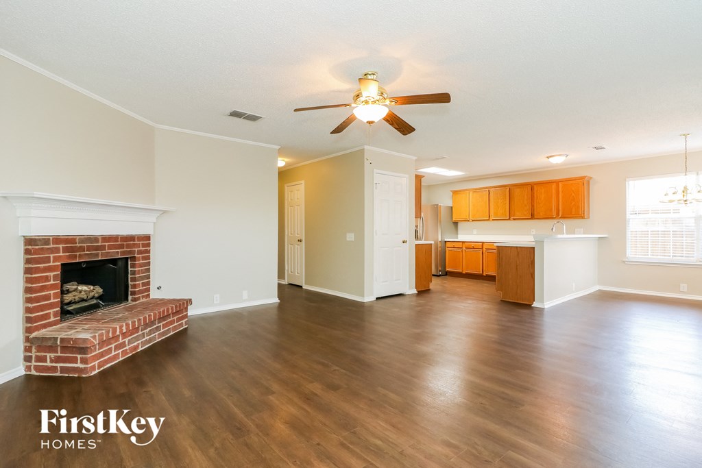 A spacious living room with a fireplace and wooden floors.
