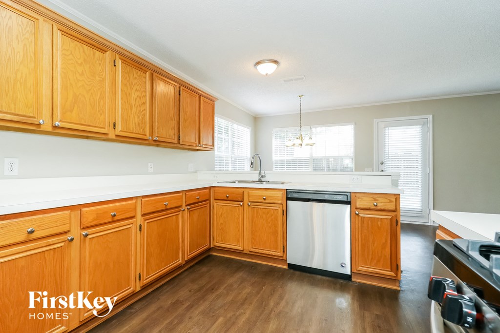 A kitchen with wooden cabinets and a white dishwasher.