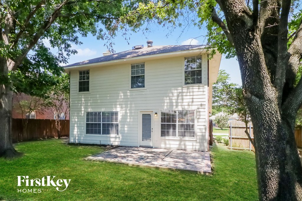 A white house with a tree in front of it.