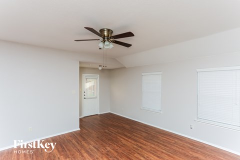 a living room with wood floors and a ceiling fan