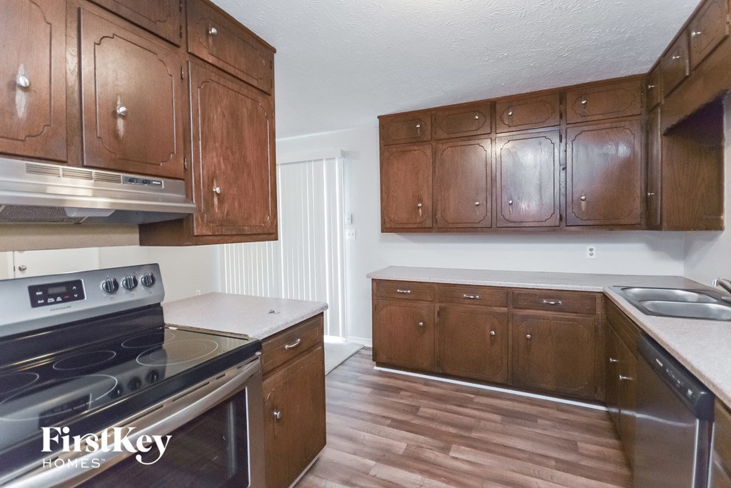 an empty kitchen with wooden cabinets and stainless steel appliances