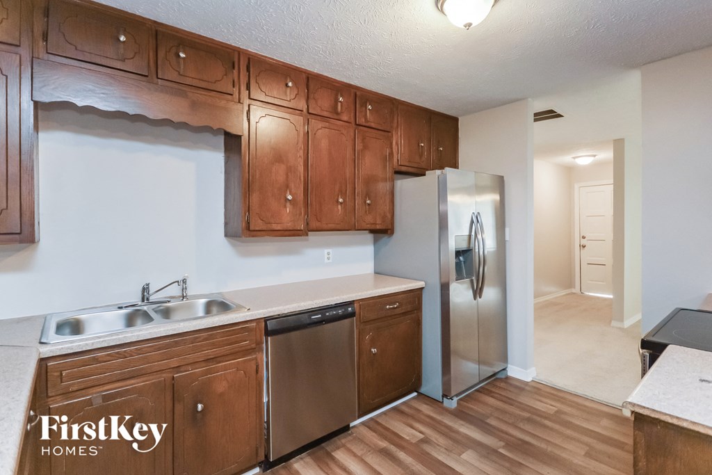 a kitchen with wooden cabinets and a stainless steel refrigerator