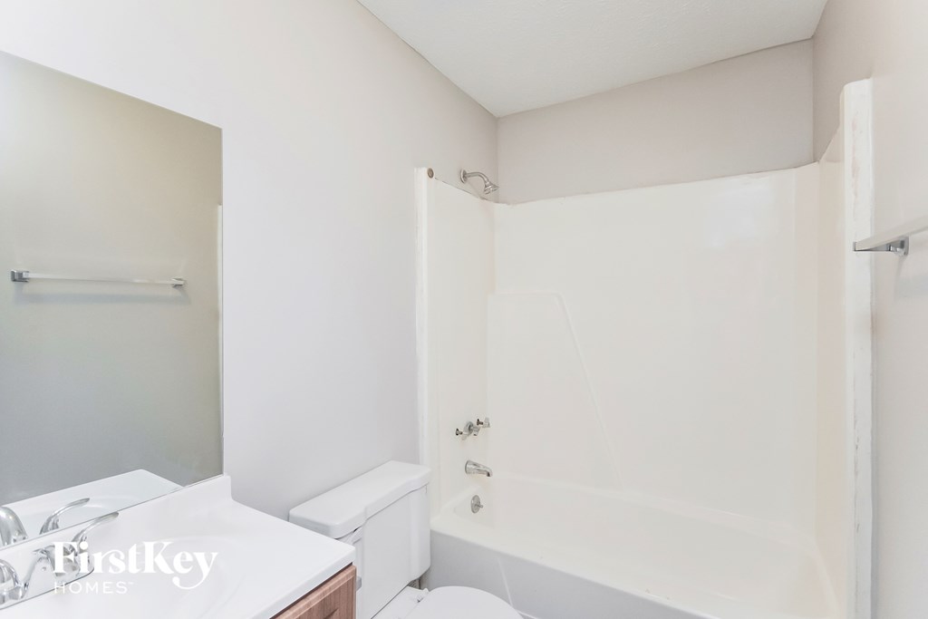 a white bathroom with a tub and a toilet and a sink