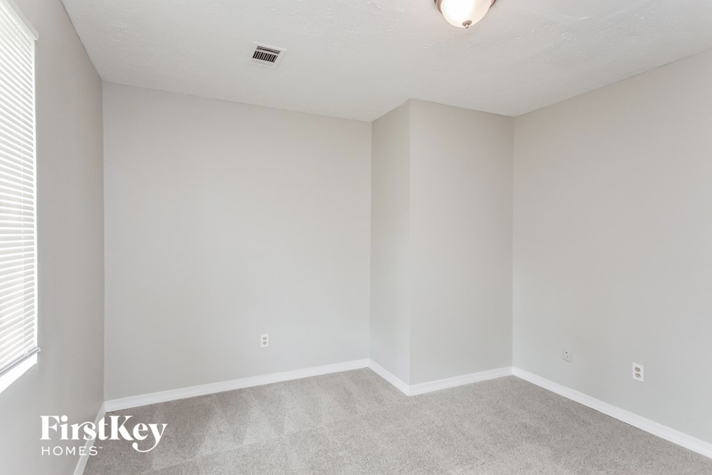 an empty room with white walls and a window