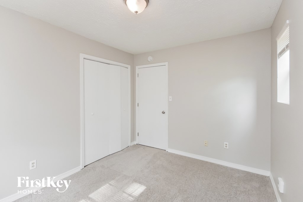 a bedroom with two doors and a carpeted floor