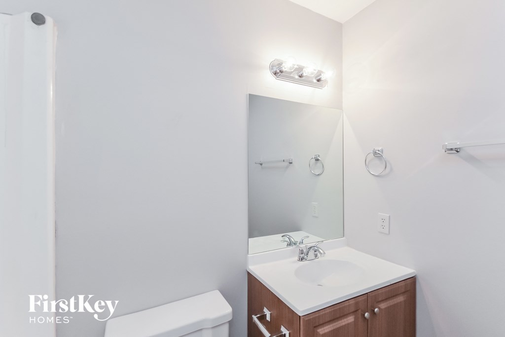 a bathroom with a mirror and a sink and a toilet