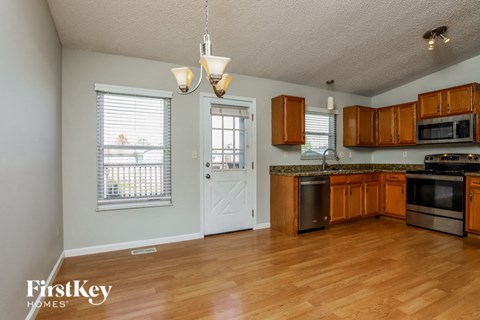 A kitchen with wooden cabinets and a white door.