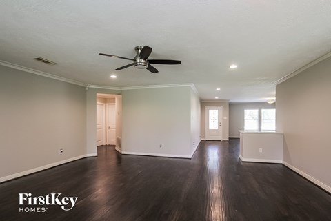 a living room with wood floors and a ceiling fan