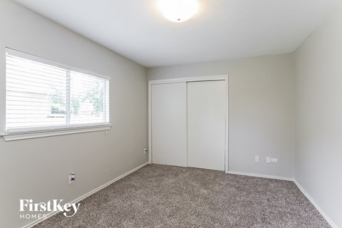 a bedroom with carpet and a window and white closet