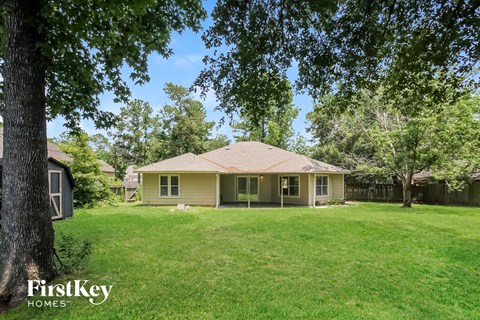 a yellow house sitting in the middle of a grassy yard