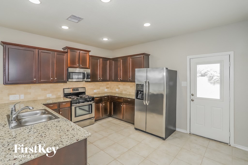 a kitchen with wooden cabinets and stainless steel appliances