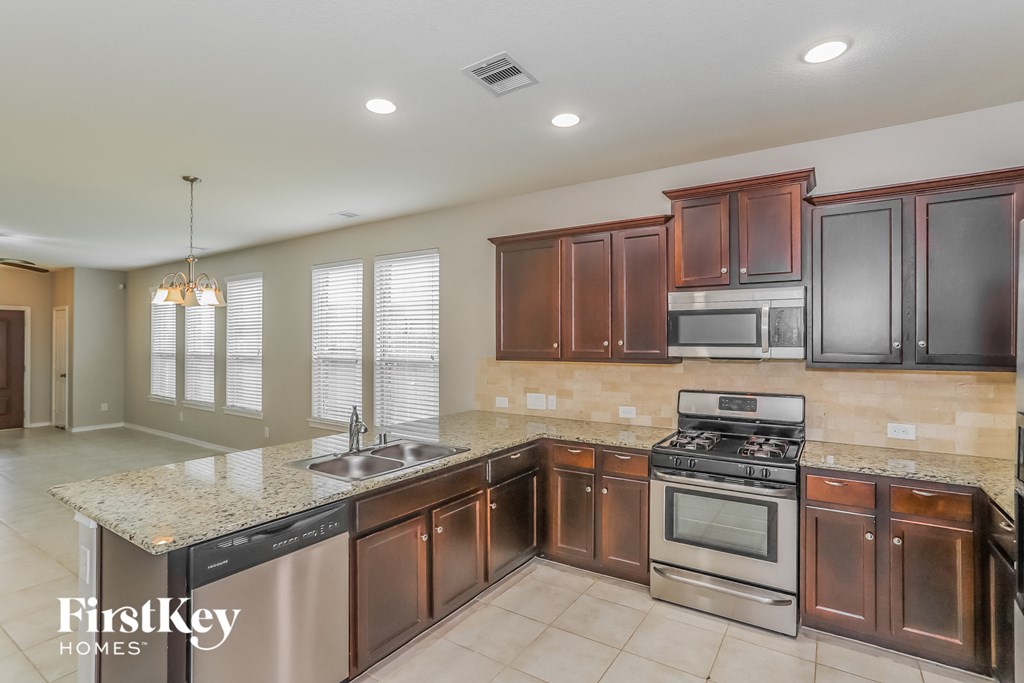a kitchen with wooden cabinets and stainless steel appliances and granite counter tops