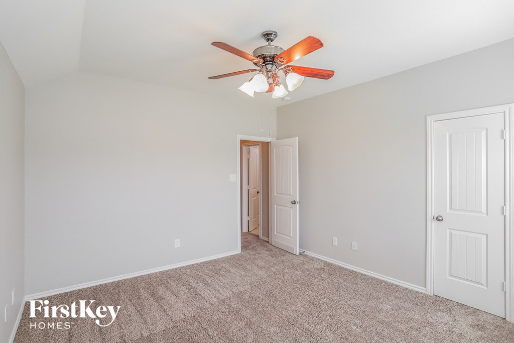 a bedroom with a ceiling fan and a door to a closet