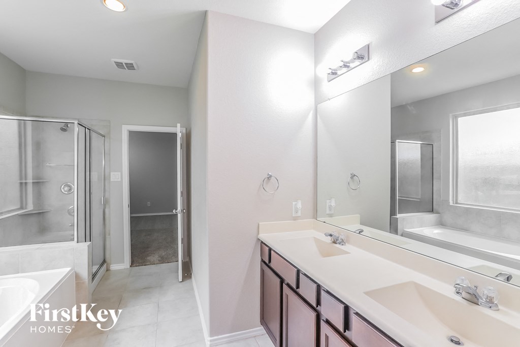 a bathroom with two sinks and a large mirror and a shower