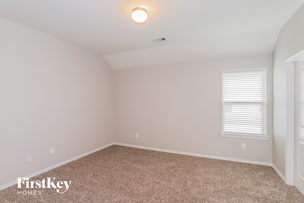 a bedroom with a carpeted floor and a window