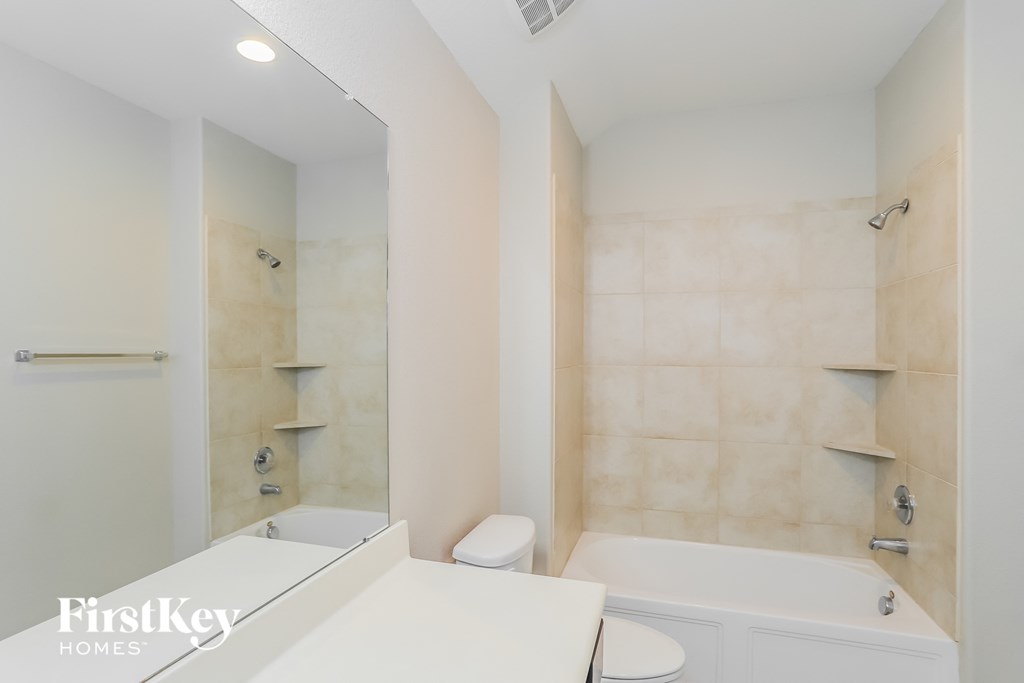 a white bathroom with a tub and a toilet and a sink