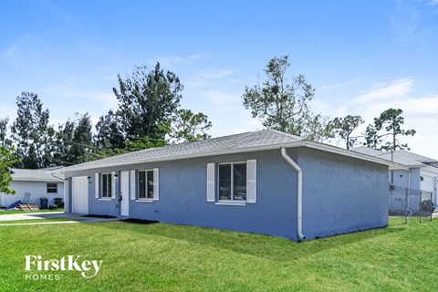 A blue house with the words "FirstKey Homes" on the lawn.
