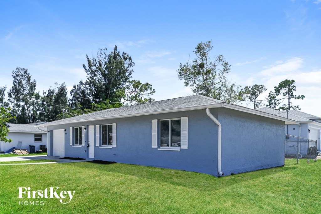 A blue house with the words "FirstKey Homes" on the lawn.