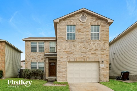 a tan brick house with a white garage door