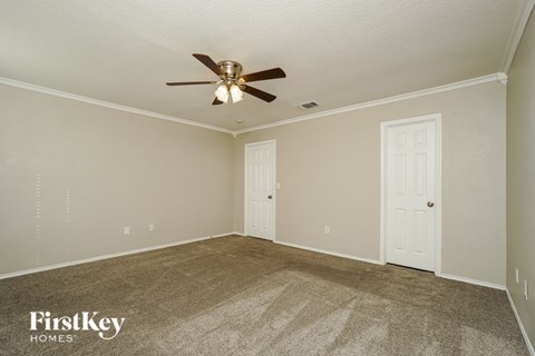 the living room of a house with a ceiling fan