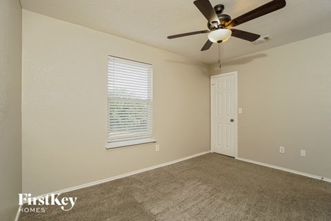 a bedroom with a ceiling fan and a door