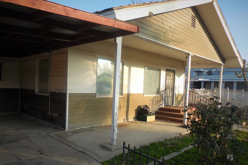 the front of a yellow house with a porch