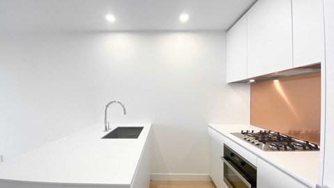 A modern kitchen with a stove and sink.