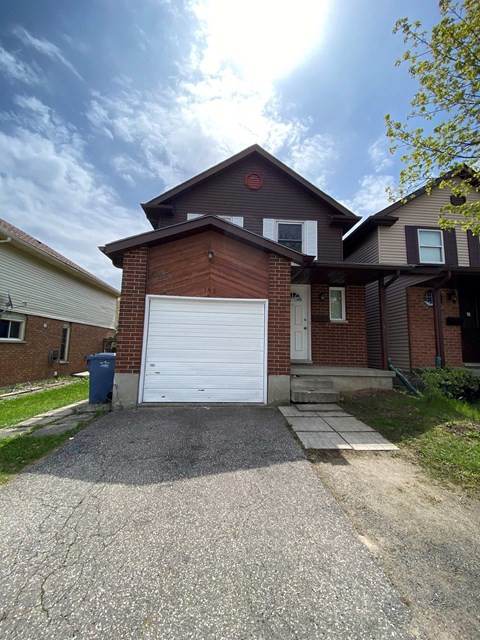 a white garage door in front of a brick house