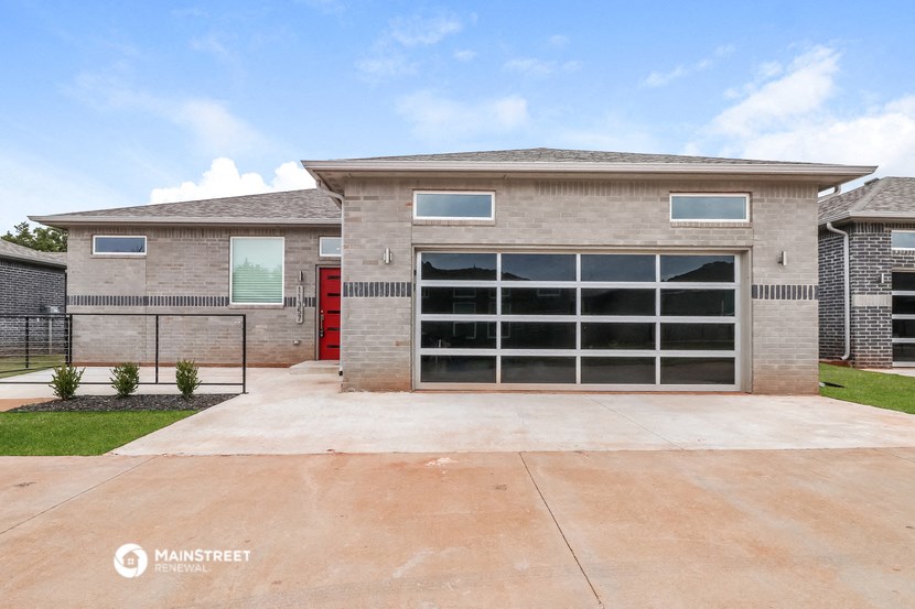 a large garage door in front of a brick house