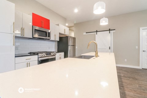 a large white kitchen with white cabinets and a white counter top