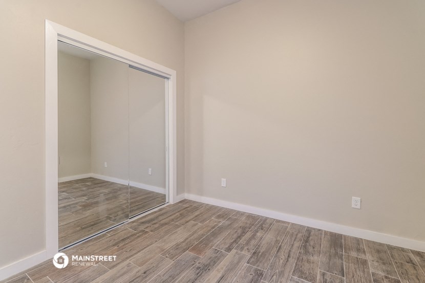 a bedroom with a sliding glass door and wood flooring