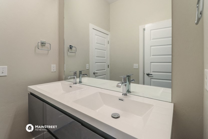 a bathroom with two sinks and a large mirror