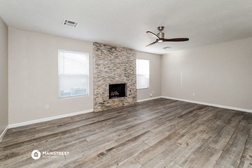 a living room with a fireplace and wooden floors