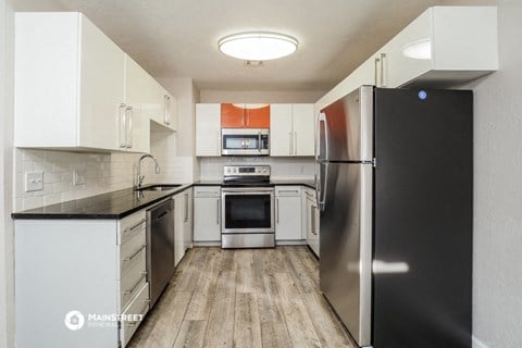 a kitchen with stainless steel appliances and white cabinets