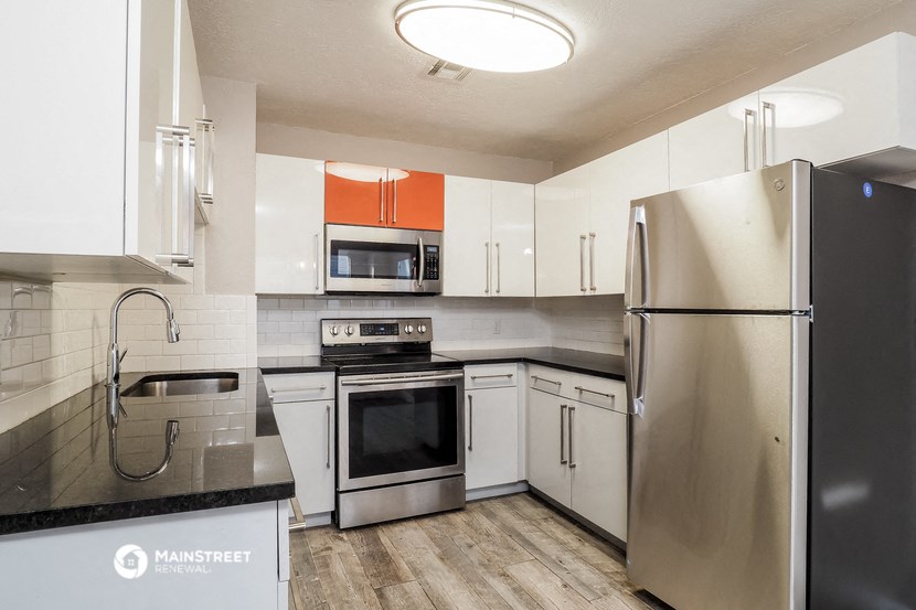 a kitchen with white cabinets and stainless steel appliances